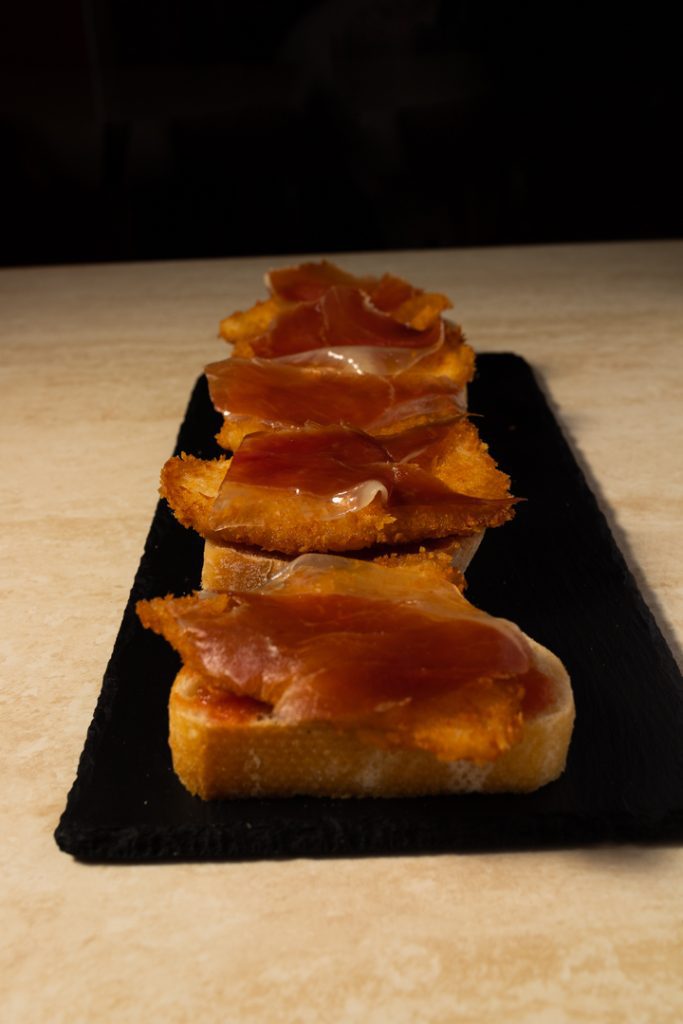 Tapa de pollo rebozado con jamon y encima de un pan Fotografo y videografo de gastronomia en Alicante